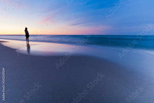 Lonely person at sunset sea. Long exposure landscape