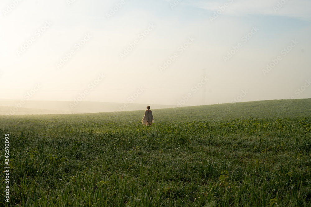 Fototapeta premium Girl in the morning foggy field