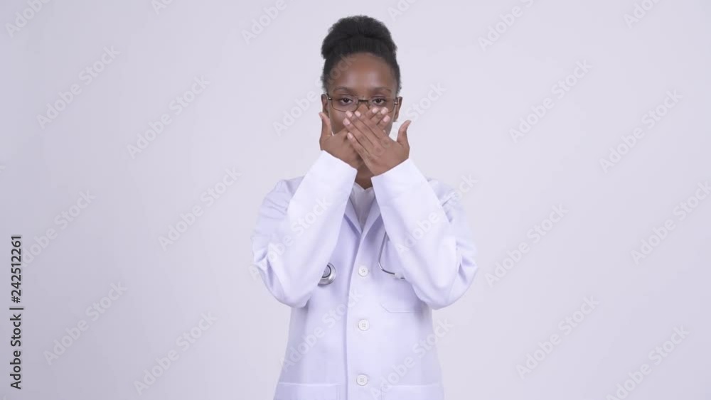 Young African woman doctor covering mouth as three wise monkeys concept Young African woman doctor covering mouth as three wise monkeys concept