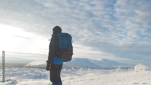 Winter hiking in the mountains, mountaineering equipment snowshoes and backpack. Man tourist mountaineer exploring the nirth of Russia, Ural Mountains trekking. Snow mountains on the background. photo