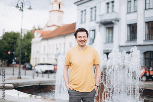 Young casual man walking along the srteet of old european town. Travelling, vacation concept