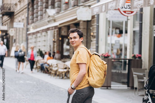 Young casual man walking along the srteet of old european town. Travelling, vacation concept photo