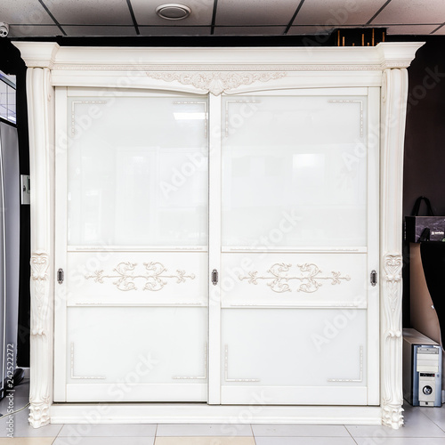 White wardrobe with sliding doors, drawer and shelves, vintage style photo