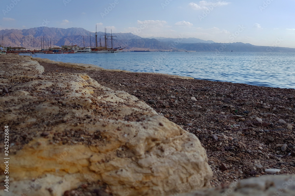 Romantic evening at the rocky public beach near harbor in Eilat, Israel