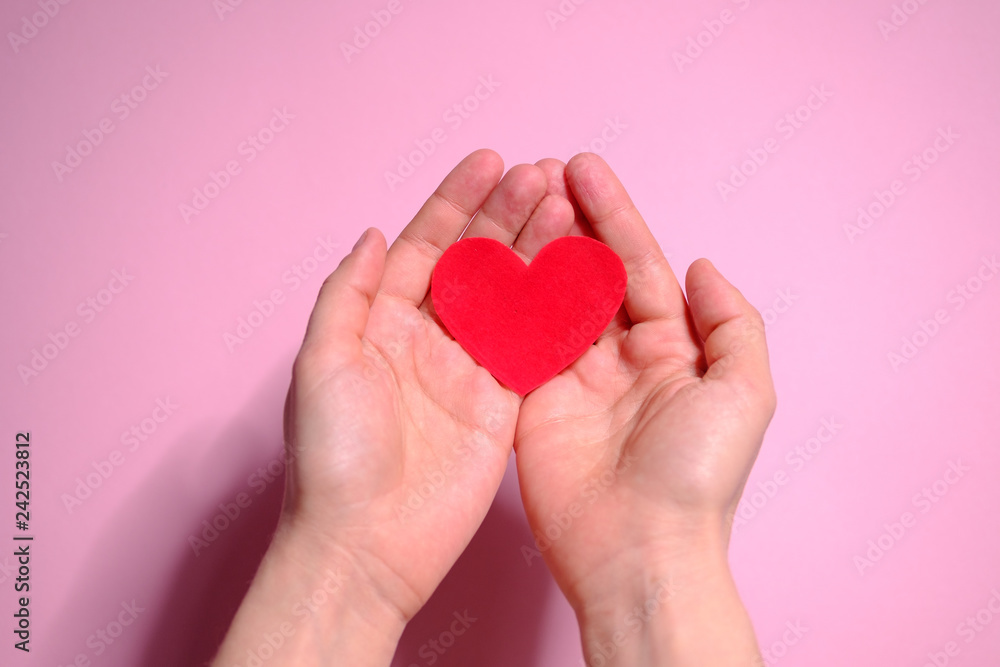 Obraz premium Heart in hands on a pink background. Valentine's Day
