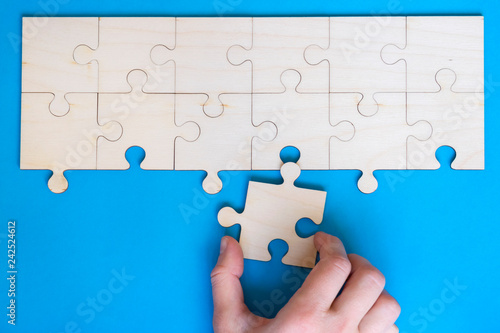 Wooden puzzle on the blue background.