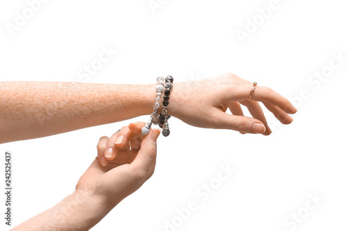 Female hands with stylish bracelets and ring on white background