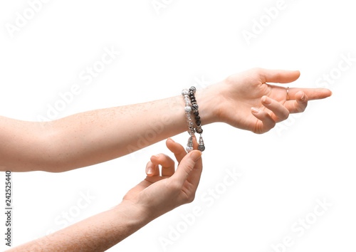 Female hands with stylish bracelets on white background