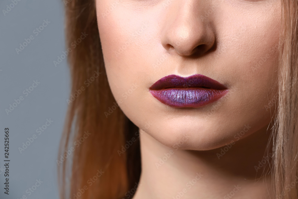 Fototapeta premium Young woman with makeup in violet tones, closeup