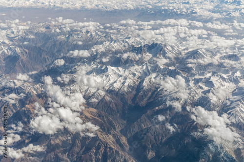 View of the snow mountains from airplane window during flight