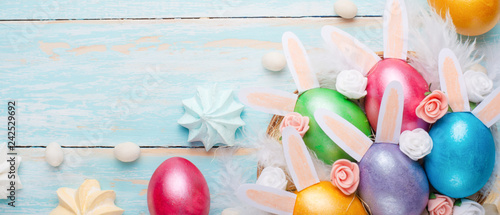 Easter colored eggs with ears of sweets and rabbit ears. Fly lay lay. Easter festive background.