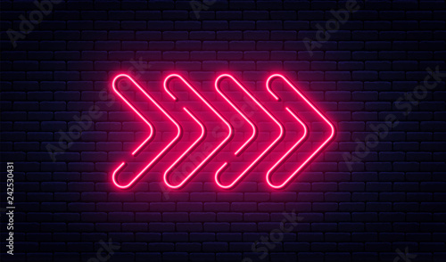 Neon arrow sign. Glowing neon arrow pointer on brick wall background. Retro signboard with bright neon tubes
