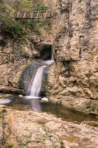 A running waterfall of river through the rocks of the mountain in autumn.