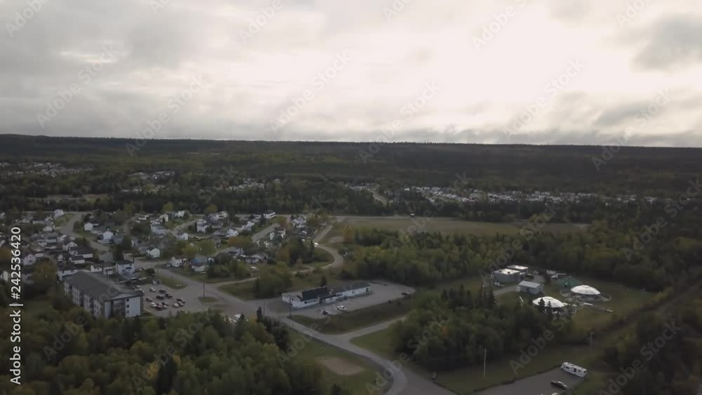 Aerial view of a small town by the river during a vibrant cloudy sunset. Taken in Brandon, Manitoba, Canada. Aerial view of a small town by the river during a vibrant cloudy sunset. Taken in Brandon, Manitoba, Canada.