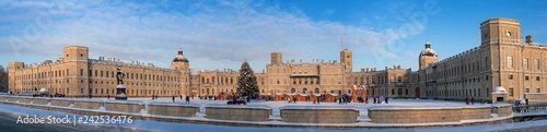 New Year and Christmas Fair on the parade ground. Panorama of the Palace Square with a monument to Paul 1, a Christmas tree, trade shops and slides for riding. Gatchina, Russia