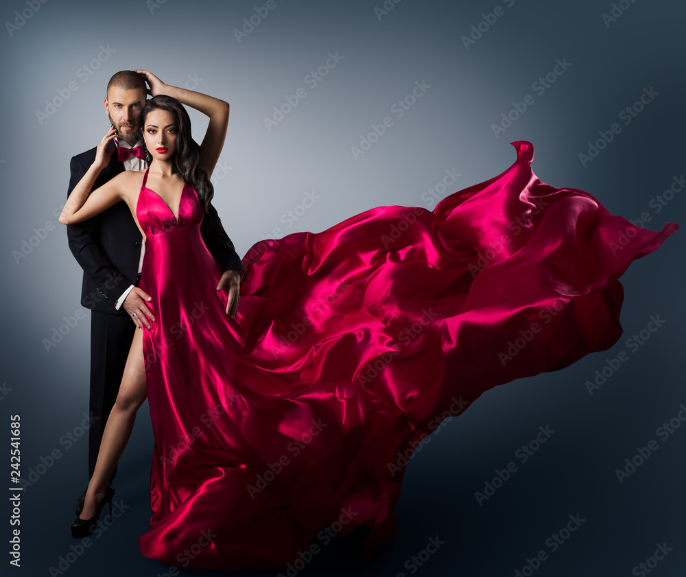Fototapeta Fashion Couple, Young Beautiful Woman in Flying Waving Dress and Elegant Man, Beauty Studio Shot