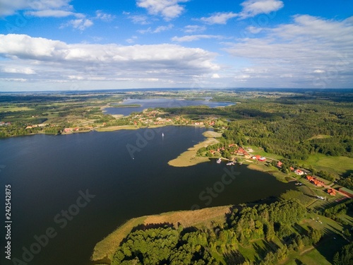 Aerial view of beautiful Ogonki village (former Ogonken or Schwenten, East Prussia) located on Swiecajty Lake shore, Mazury, Poland photo