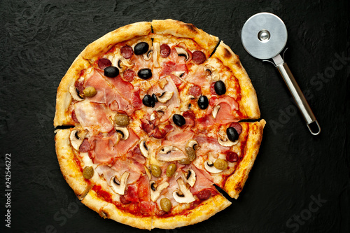 Tasty pizza on black concrete  background. 