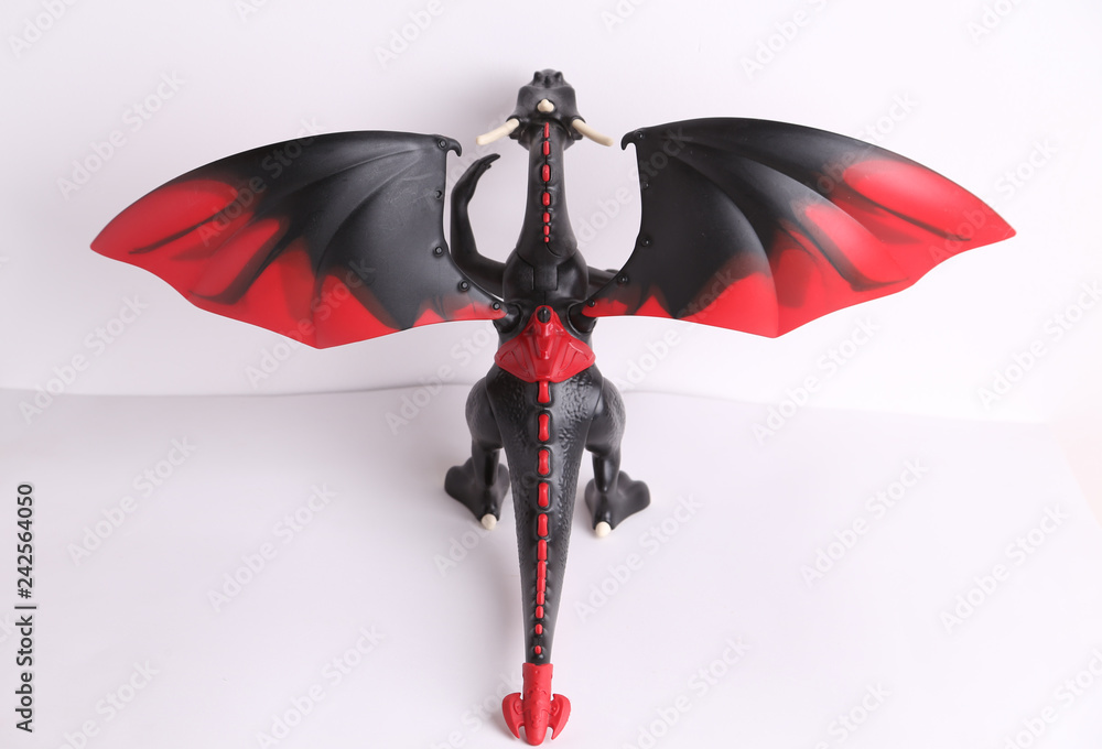 black and red dragon toy on white background