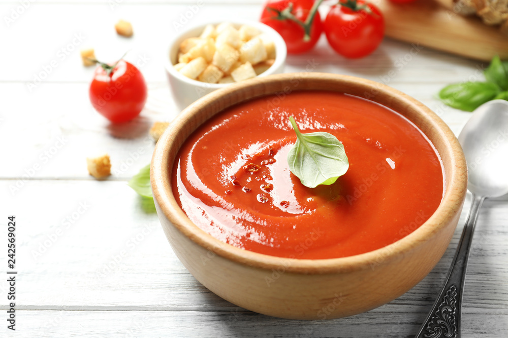 Bowl with fresh homemade tomato soup on wooden table Bowl with fresh homemade tomato soup on wooden table