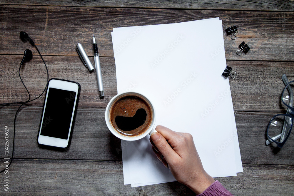 Woman hand holding coffee on working table Woman hand holding coffee on working table