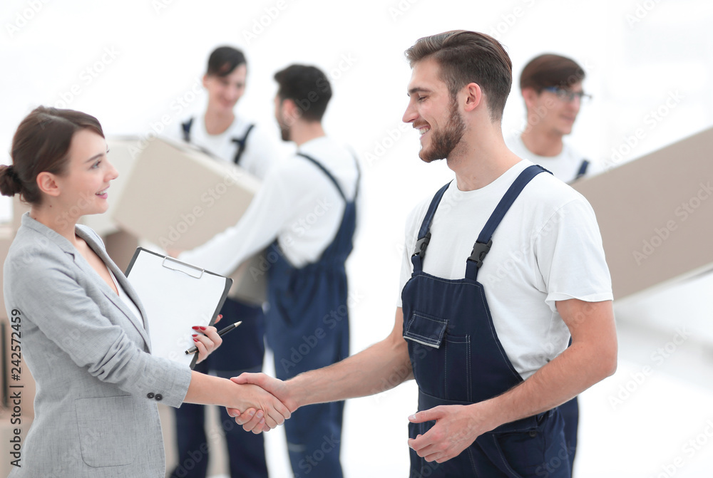 Manager with clipboard shaking hands with movers. Manager with clipboard shaking hands with movers.