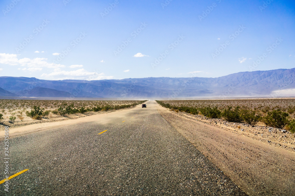 Driving through Panamint Valley; sand carried on the road by wind; Mojave Desert, California