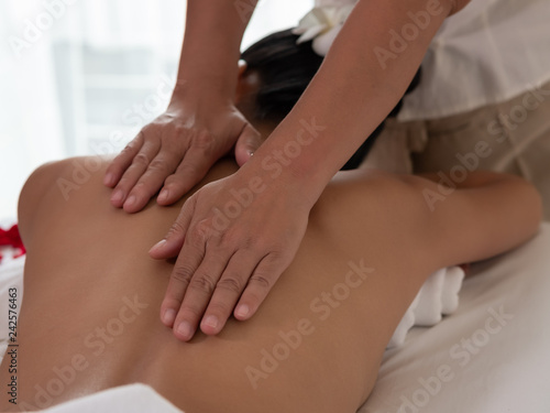 Hand of masseuse's on the backs of Asian woman are a relaxing on bed. Massage and body care. Spa in salon