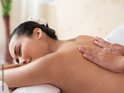 Hand of masseuse's on the backs of women. Asian woman are a relaxing on the bed. Massage and body care. Spa in salon