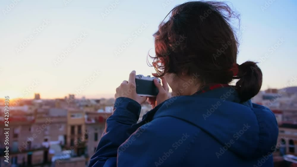 Young hipster student in Erasmus new in city learning photography as a hobby and taking an analog photo or picture by lomo old film camera of view of rooftop during sunset or sunrise in Europe town Young hipster student in Erasmus new in city learning photography as a hobby and taking an analog photo or picture by lomo old film camera of view of rooftop during sunset or sunrise in Europe town