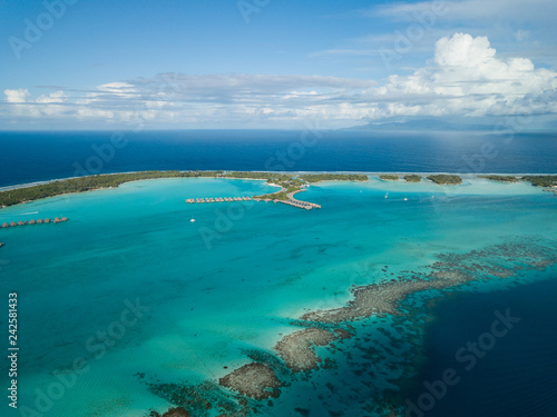 Luxury overwater villas with coconut palm trees, blue lagoon, white sandy beach at Bora Bora island, Tahiti, French Polynesia © bomboman