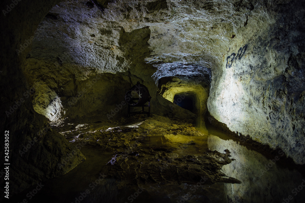 Water reflections inside dark dirty flooded abandoned mine