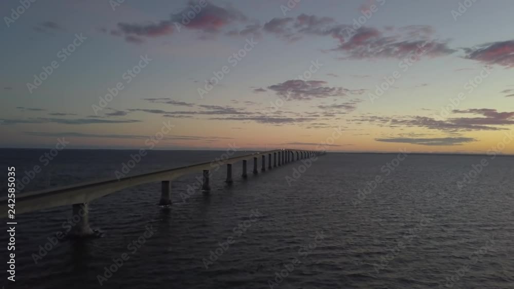 Aerial view of Confederation Bridge to Prince Edward Island during a vibrant sunny sunrise. Taken in Cape Jourimain National Wildlife Area, New Brunswick, Canada.