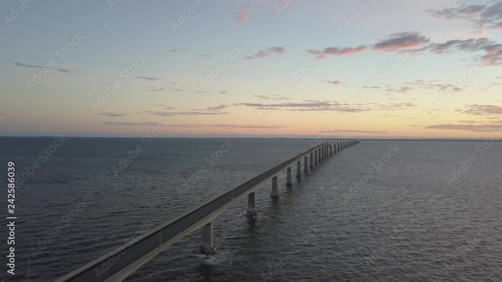 Aerial view of Confederation Bridge to Prince Edward Island during a vibrant sunny sunrise. Taken in Cape Jourimain National Wildlife Area, New Brunswick, Canada. Aerial view of Confederation Bridge to Prince Edward Island during a vibrant sunny sunrise. Taken in Cape Jourimain National Wildlife Area, New Brunswick, Canada.