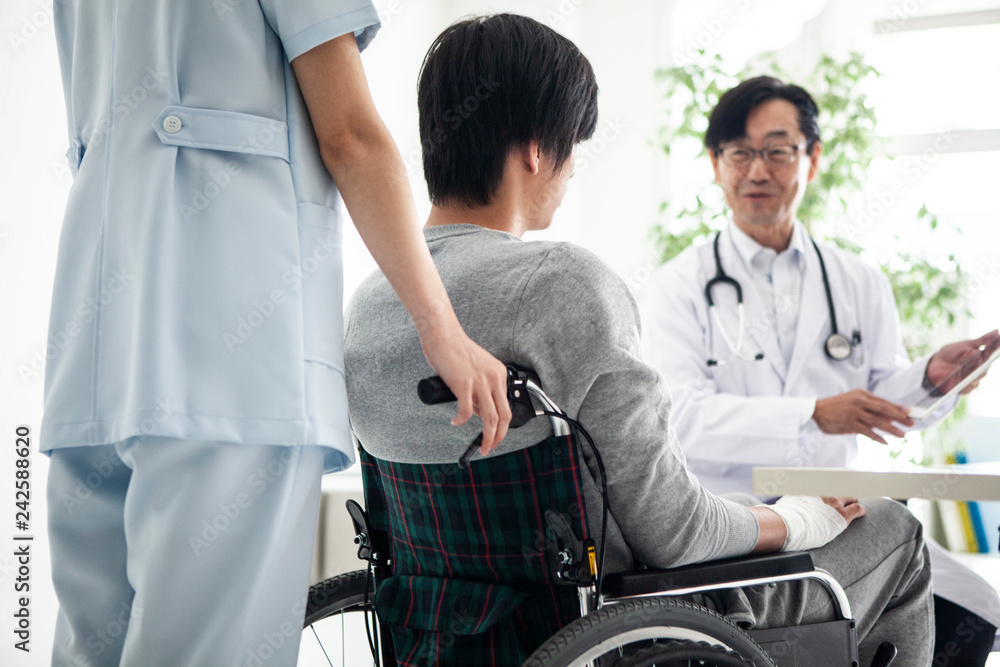 看護師が患者の車椅子をしっかりと支えている 看護師が患者の車椅子をしっかりと支えている
