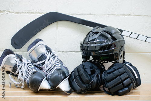 Adult hockey equipment: skates , gloves, helmet and stick on the brick wall background