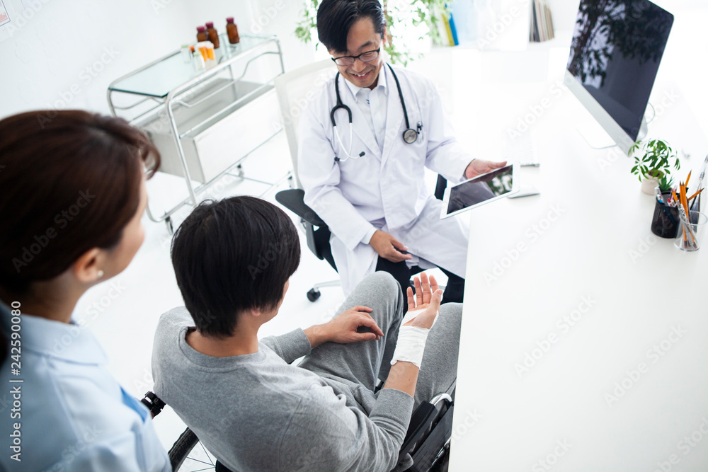 © Monet - タブレットで現在の状況を確認する主治医と患者