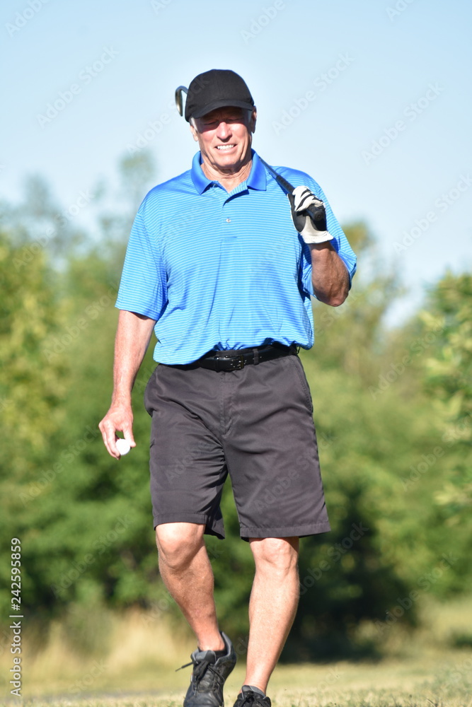 Fototapeta premium Golfer With Golf Club Walking