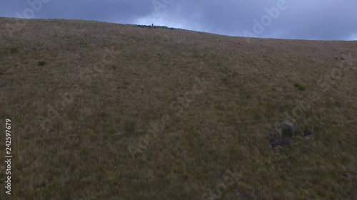 Two People Stand at the Top of a Ridge and Look Down