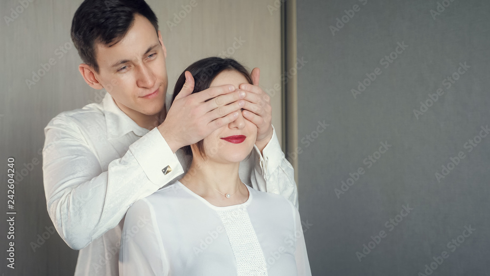 man closes his is girlfriend's eyes to make surprise man closes his is girlfriend's eyes to make surprise