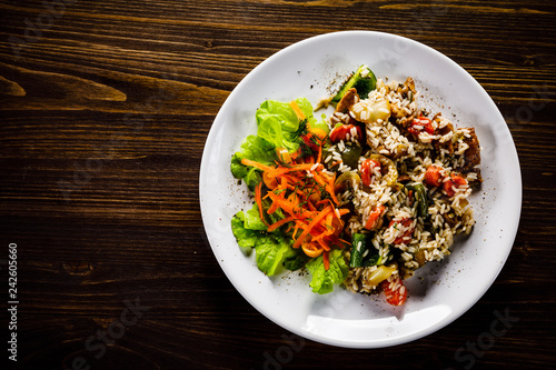 Grilled meat, white rice and vegetables on wooden table