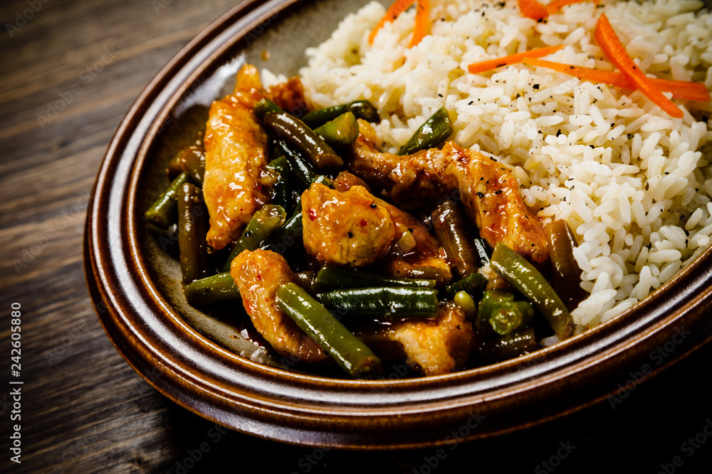 Grilled meat, white rice and vegetables on wooden table Grilled meat, white rice and vegetables on wooden table