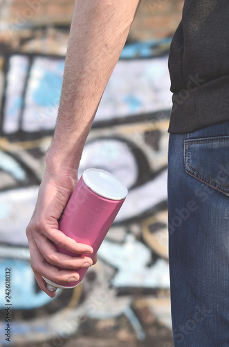 Rear view of a guy drawing a wall with aerosol paint photo