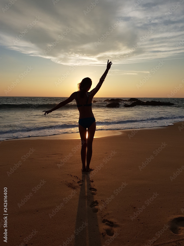 Dancing girl at sunset on the Indian Ocean