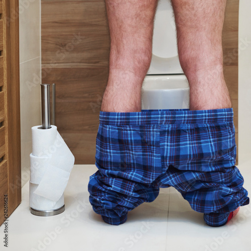 Obraz na plátně Low section of man urinating in the toilet