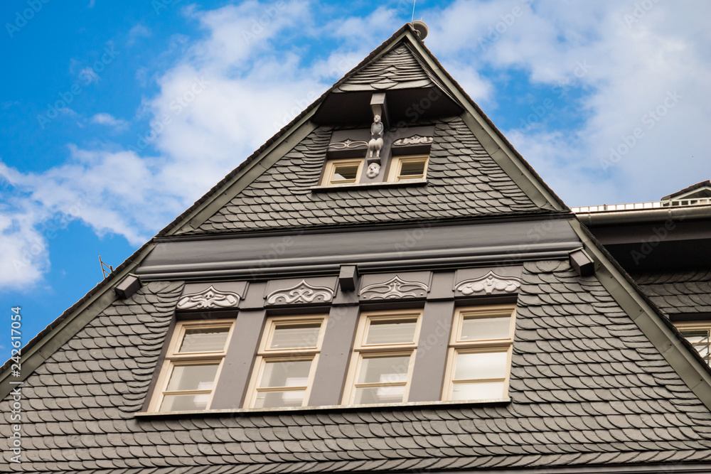 Renovierte Häuserfassade mit schwarzen Schindeln Renovierte Häuserfassade mit schwarzen Schindeln