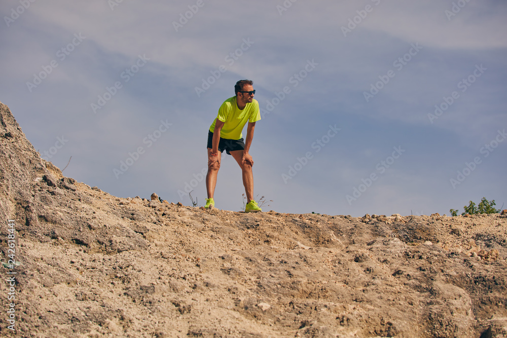 Sportsman climbing the rock / hill for hard exercise.