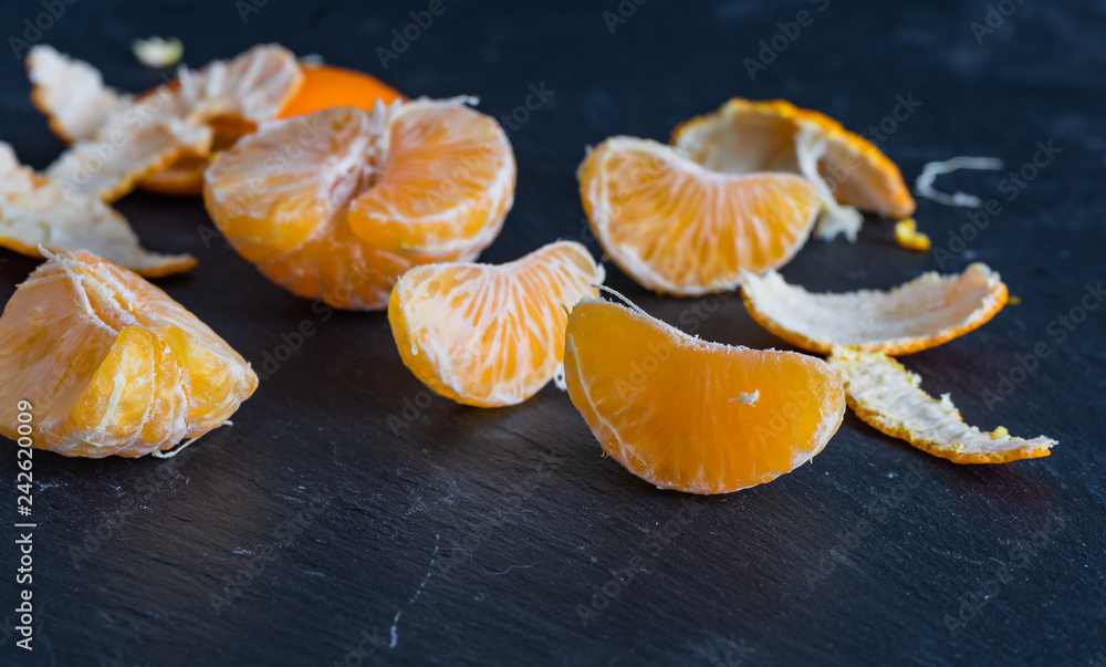Mandarinen und Schnitze auf dunklem Hintergrund