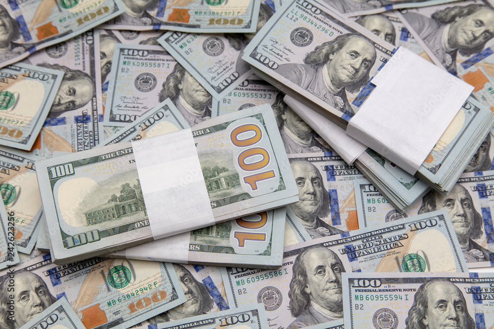 One hundred dollar bills on the table as background One hundred dollar bills on the table as background