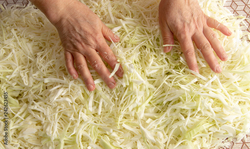 Woman salting cabbage in the kitchen